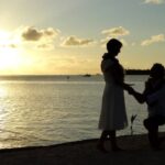 A Message for Newly Wed Couple Two happy newlyweds holding hands and smiling, with a beautiful sunset in the background - A Message for Newly Wed Couple
