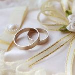 Smiling bride and groom in formal attire outdoors