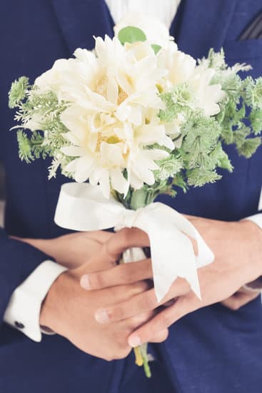 Bride and groom's hands holding wedding rings - WHO HOLDS THE RINGS AT A WEDDING
